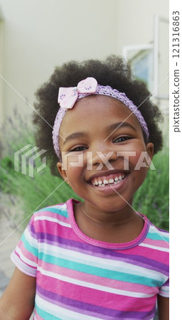 Vertical image portrait of happy african american girl smiling in garden Vertical image portrait of happy african american girl smiling in garden 121316863
