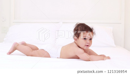 Cute baby playing on bed Cute baby playing on bed 121316954