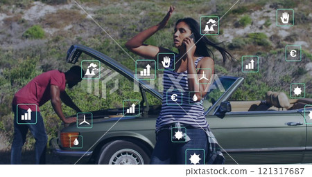 Image of eco icons over diverse man fixing car and woman on the phone by car 121317687