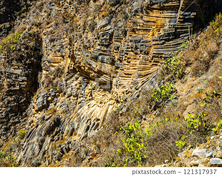 The striking rock formations of Colca Canyon reveal layers of geological history and vibrant vegetation. This breathtaking landscape showcases nature's artistry in a remote setting. The striking rock formations of Colca Canyon reveal layers of geological history and vibrant vegetation. This breathtaking landscape showcases nature's artistry in a remote setting. 121317937