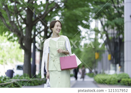 一位中年婦女在綠樹叢中購物 121317952