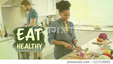 Image of eat healthy text over diverse couple preparing healthy meal in kitchen 121318082