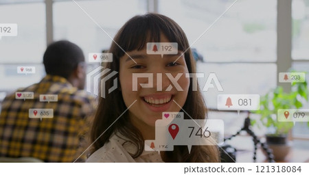 Image of icons and numbers over biracial businesswoman in office 121318084