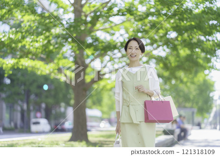 A middle-aged woman shopping in the fresh greenery A middle-aged woman shopping in the fresh greenery 121318109
