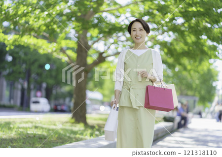 A middle-aged woman shopping in the fresh greenery A middle-aged woman shopping in the fresh greenery 121318110