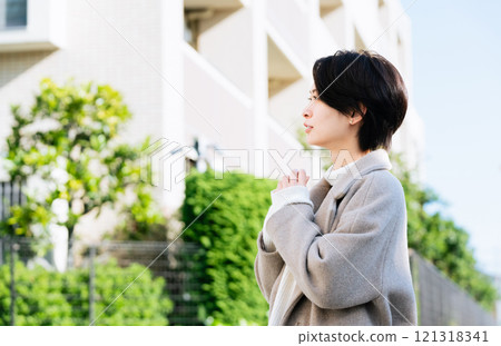穿著外套在戶外散步的女人 121318341