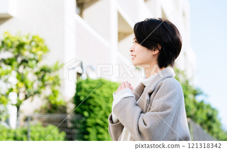 A woman in a coat walking outdoors A woman in a coat walking outdoors 121318342
