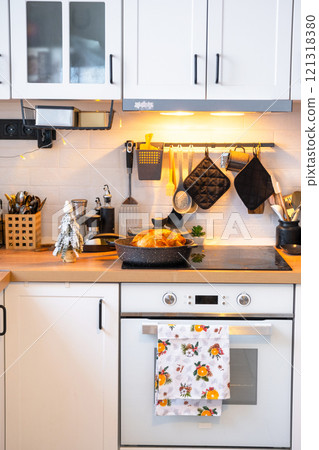 Christmas decor in white kitchen, modern rustic interior with a snowy Christmas tree and gold fairy lights. New Year, Christmas mood, cozy home. 121318380