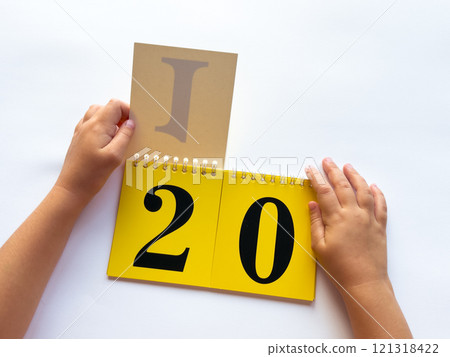 Childs hands flip through yellow pages with numbers on a white background Childs hands flip through yellow pages with numbers on a white background 121318422