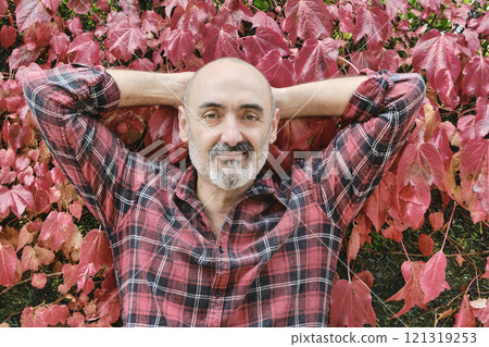 Man portrait in a checked shirt with an autumnal background Man portrait in a checked shirt with an autumnal background 121319253