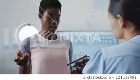 Image of financial data processing over diverse colleagues discussing work in office Image of financial data processing over diverse colleagues discussing work in office 121319491