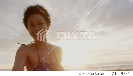 Low angle view of African American couple running together hand in hand on the beach 121319785