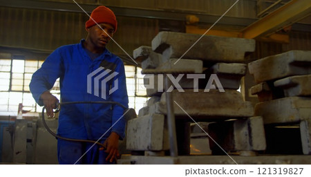 Worker heating metal mold with blow torch in foundry workshop Worker heating metal mold with blow torch in foundry workshop 121319827