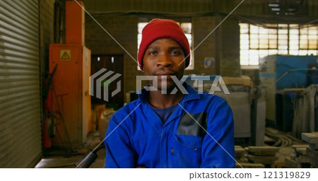 Male worker standing with arms crossed in workshop 121319829