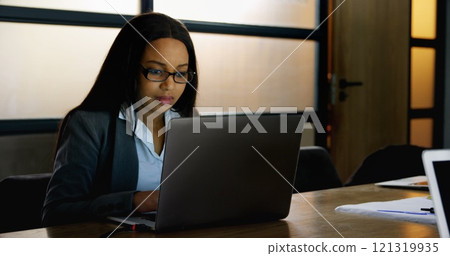 Front view of a happy smiling businesswoman using laptop for work in office 121319935