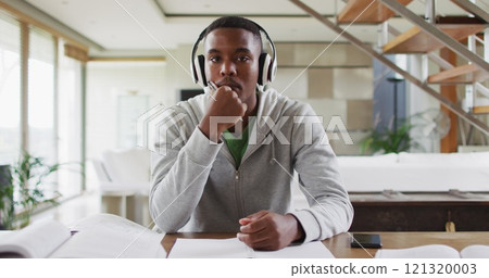 African american male teenager wearing headphones having a image conversation African american male teenager wearing headphones having a image conversation 121320003