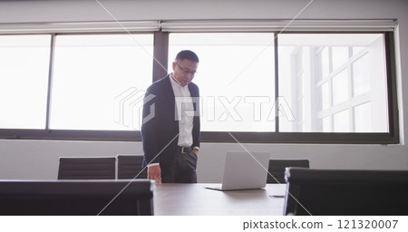 Asian businessman at the office of a creative business, using a laptop computer 121320007