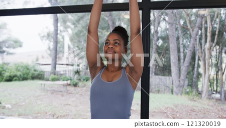 Portrait of african american woman meditating in yoga studio 121320019