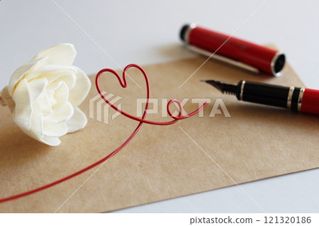 White sola flower and brown message card, image of writing with red fountain pen, red heart wire White sola flower and brown message card, image of writing with red fountain pen, red heart wire 121320186