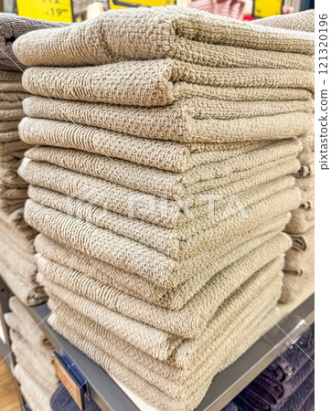 Stacks of soft, fluffy beige towels on a store shelf. High quality photo Stacks of soft, fluffy beige towels on a store shelf. High quality photo 121320196