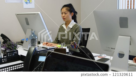 Beautiful female executive working on computer in office 121320611