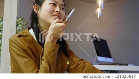 Female executive talking on mobile phone in office cafeteria 121320617