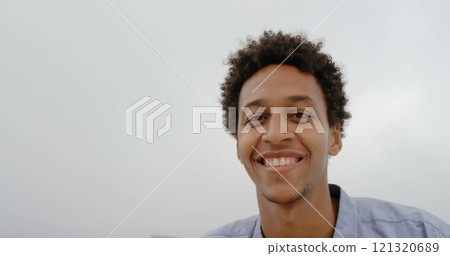 Front view of African American man standing on the beach 121320689