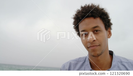 Front view of African American man standing on the beach 121320690