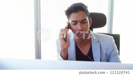 Executive talking on mobile phone in office Executive talking on mobile phone in office 121320741