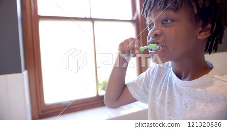 African american boy brushing teeth in bathroom at home, slow motion African american boy brushing teeth in bathroom at home, slow motion 121320886