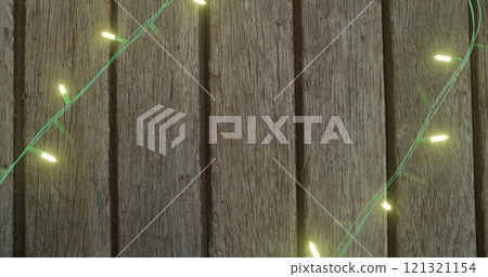 Image of fairy lights on wooden background 121321154