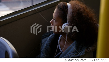 Thoughtful girl listening music while travelling in bus 121321455