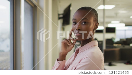 Portrait of african american creative businesswoman touching face, looking at camera 121321465