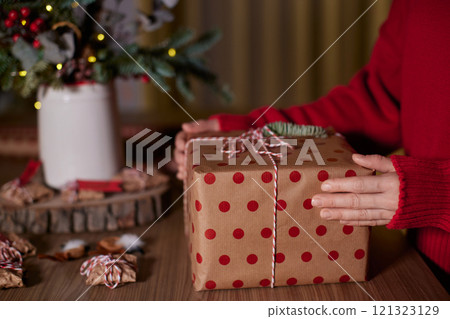 female hands holding Christmas gift box at home, New Year's Eve female hands holding Christmas gift box at home, New Year's Eve 121323129