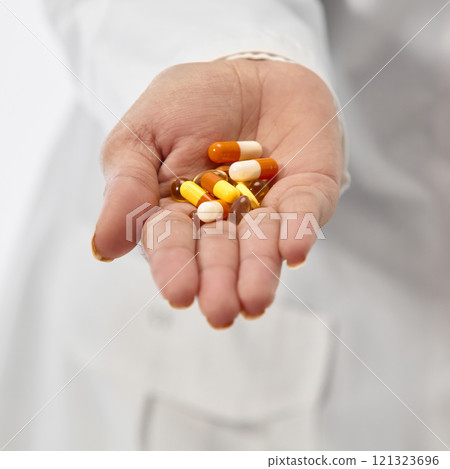 Close up photo of doctor's hands holding pills, vitamins and dietary supplements against white studio background. medical treatments. Close up photo of doctor's hands holding pills, vitamins and dietary supplements against white studio background. medical treatments. 121323696