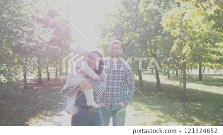 A joyful family moment outdoors in a beautiful sunlit park, celebrating love and genuine connection together A joyful family moment outdoors in a beautiful sunlit park, celebrating love and genuine connection together 121324652
