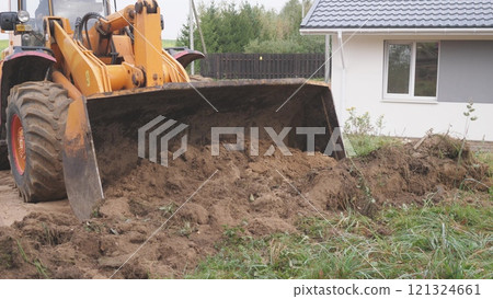 A bulldozer is actively moving dirt within a residential area, as it prepares for upcoming construction work A bulldozer is actively moving dirt within a residential area, as it prepares for upcoming construction work 121324661
