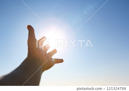 New Year's sunrise, the bright light shining through the fingers and hands stretched out toward the rising sun, the concept of hope and wishes for the future 121324789