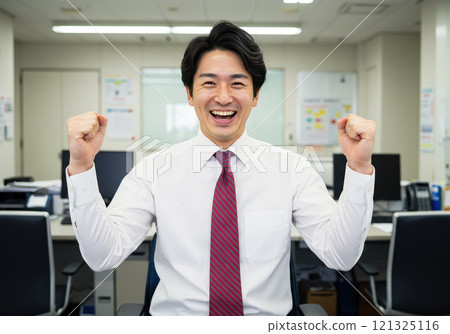 Male employee doing fist pump in the office 121325116