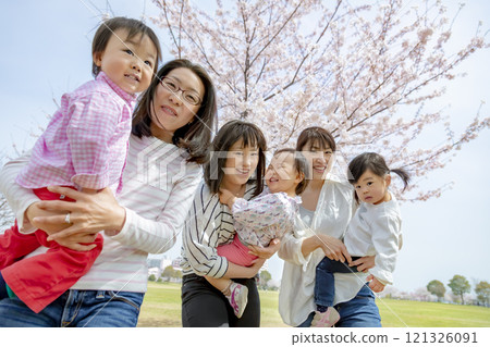 Mother and children playing in a park with cherry blossoms 121326091