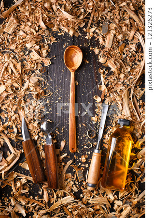 Cozy handcrafted wooden spoon with heap of wooden filings 121326273