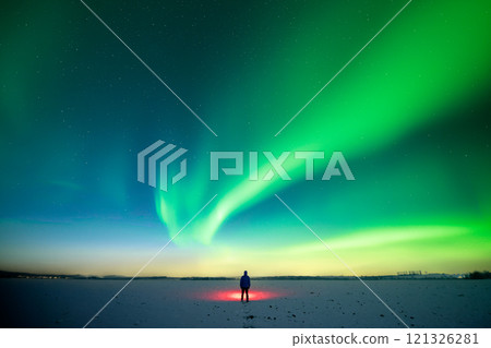 Man with red flashlight standing on snowy field 121326281