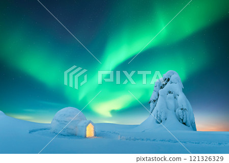 Wintry scene with glowing polar lights and snowy igloo 121326329