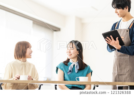 一名男員工和兩名女孩在時尚咖啡館接受訂單 121326388