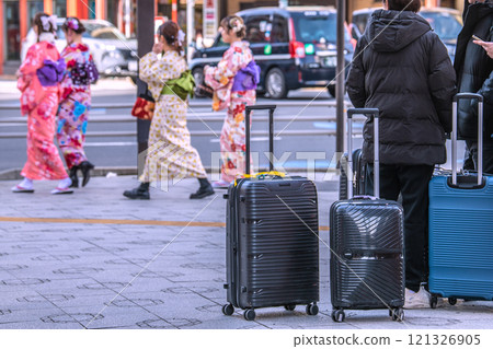 年底的日本東京城市景觀。入境旅遊仍在繼續…提著行李箱的遊客不斷抵達淺草站和吾妻橋十字路口前… 年底的日本東京城市景觀。入境旅遊仍在繼續…提著行李箱的遊客不斷抵達淺草站和吾妻橋十字路口前… 121326905