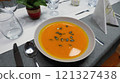 Creamy orange pumpkin soup with seeds served on a table. 121327438