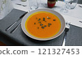 Creamy orange pumpkin soup with seeds served on a table. 121327453