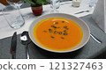 Creamy orange pumpkin soup with seeds served on a table. 121327463
