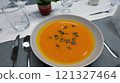 Creamy orange pumpkin soup with seeds served on a table. 121327464