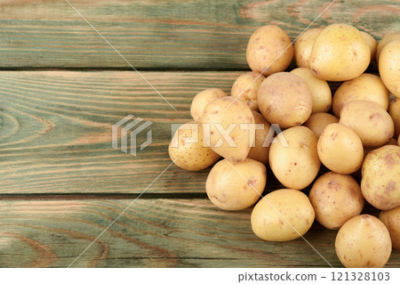 Washed unpeeled ripe baby potatoes on a wooden surface. 121328103
